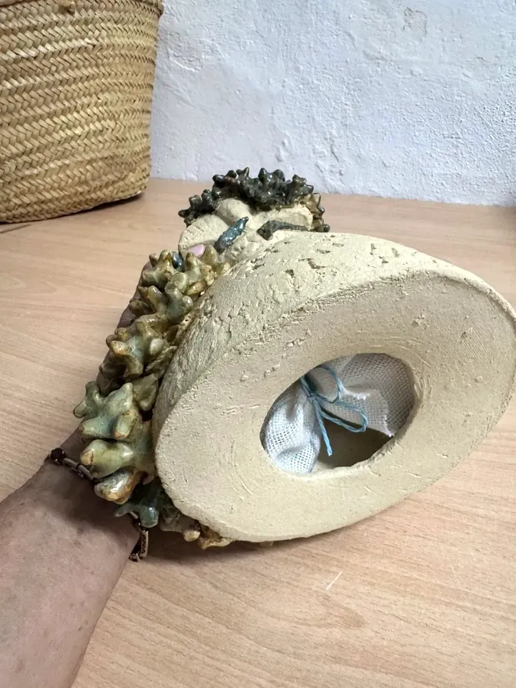 El saquito de arena introducido por el hueco de la base de la escultura