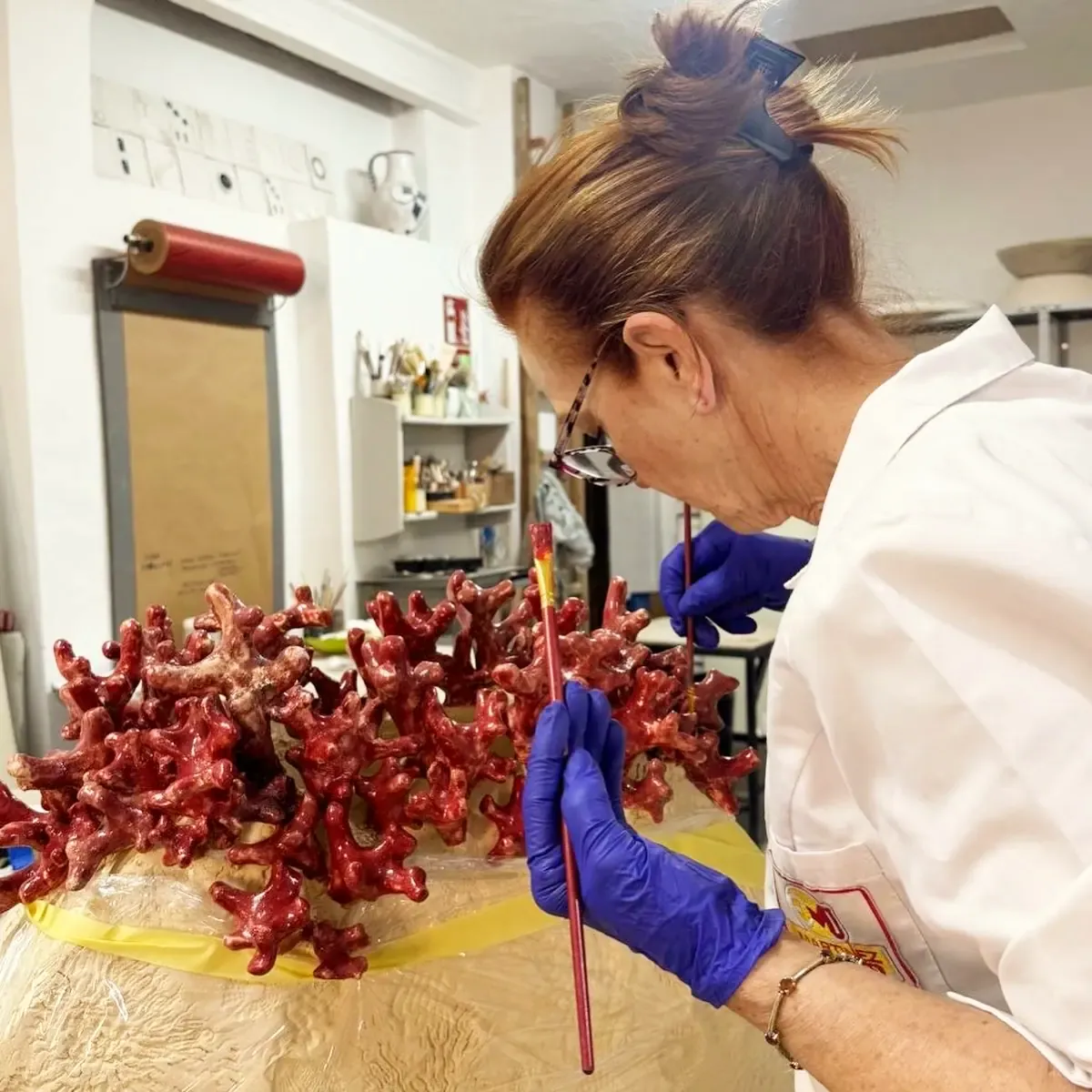 Maribel Martínez esmaltando los corales en rojo