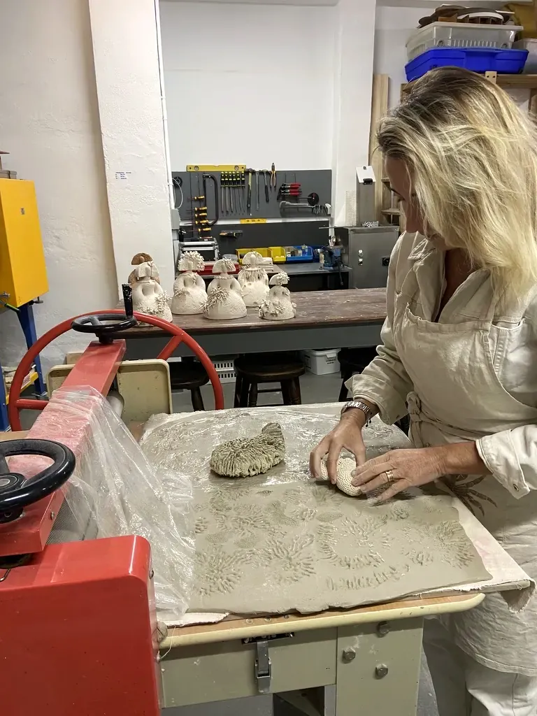 Marcando la plancha de barro con corales y conchas reales